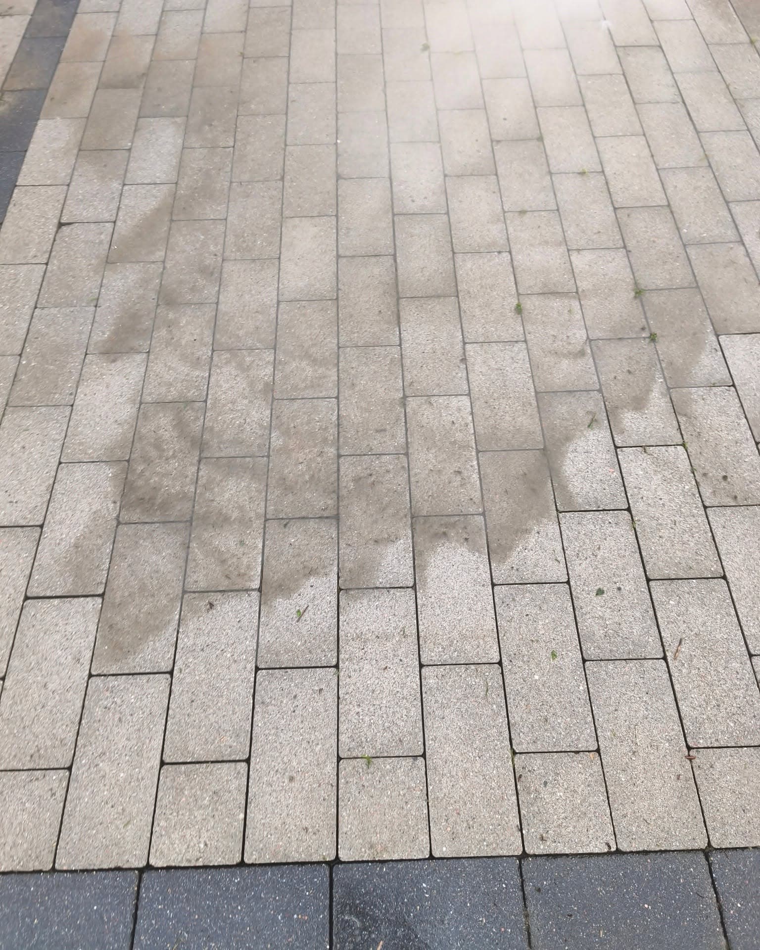Mycie ciśnieniowe kostki brukowej, widoczna granica czystej powierzchni